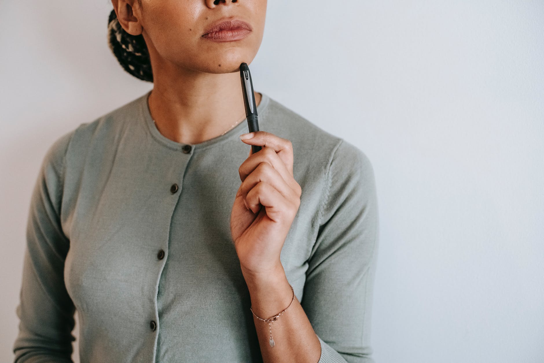 pensive woman standing with pen in light room
